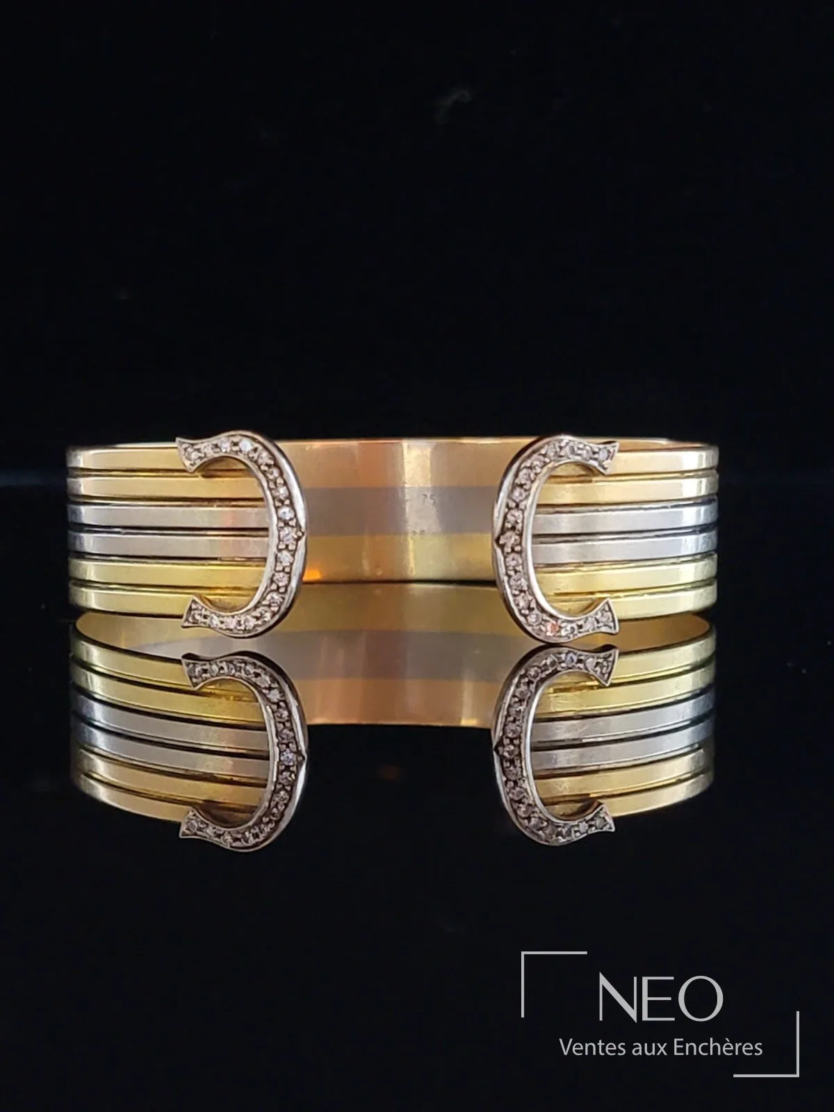 Bracelet jonc Double C de Cartier en ors jaune et gris sertis de diamants, vendu par NEO Enchères