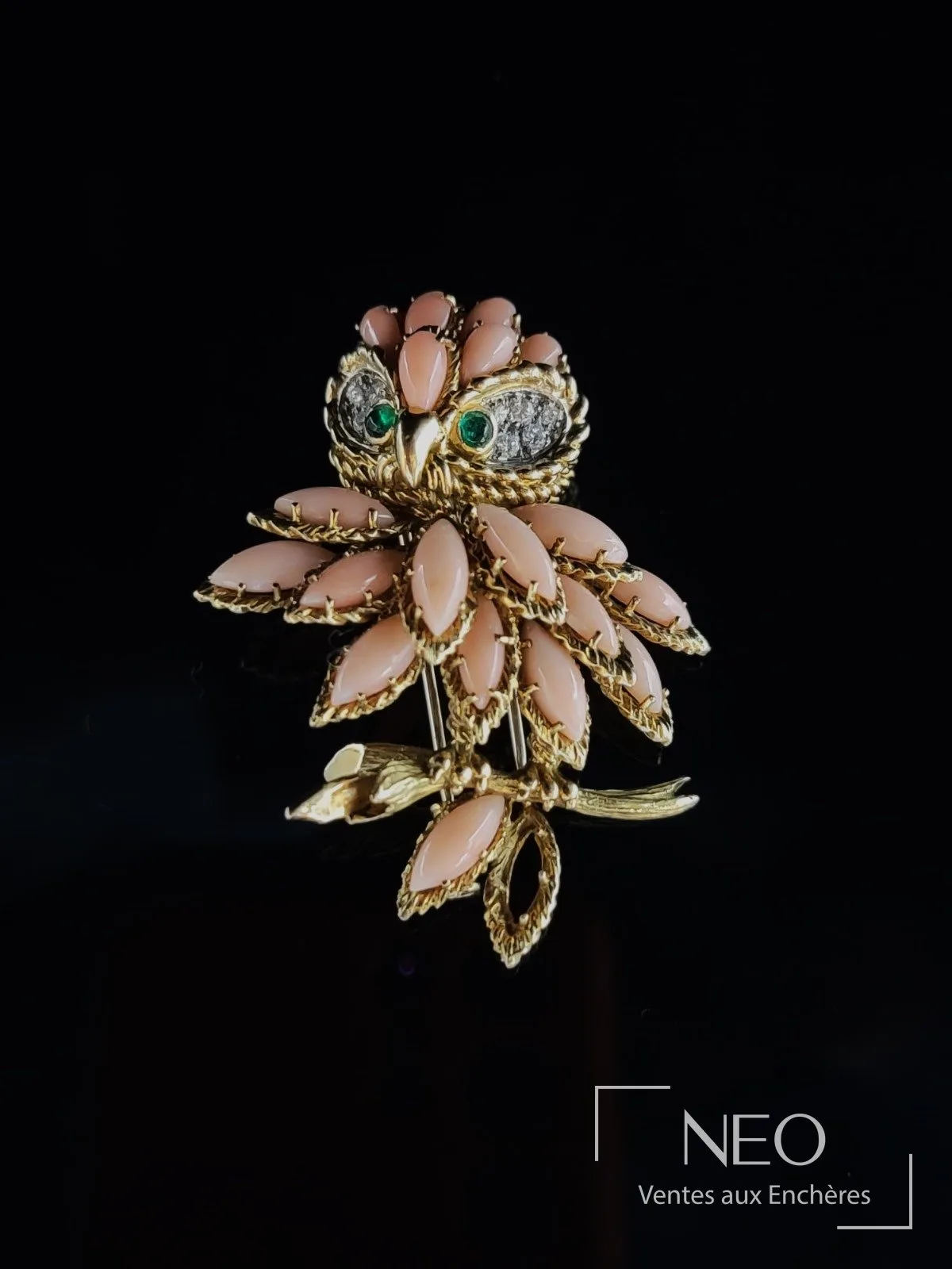 Broche chouette Van Cleef & Arpels en or jaune, corail peau d’ange, diamants et émeraudes, vendue par NEO Enchères